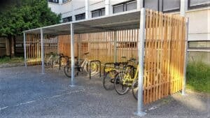 Un abri vélo en bois avec une quinzaine de vélos