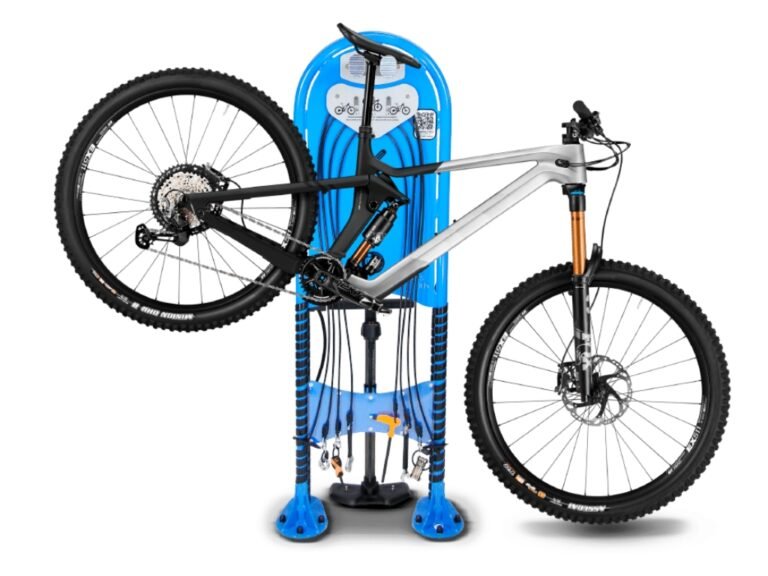 Station de réparation vélo Ifix avec vélo, station de maintenance vélo, station de service pour vélos, borne de réparation vélo, outils de maintenance vélo, station de réparation en plein air, support vélo intégré, réparation de vélos tout terrain, service de maintenance vélo