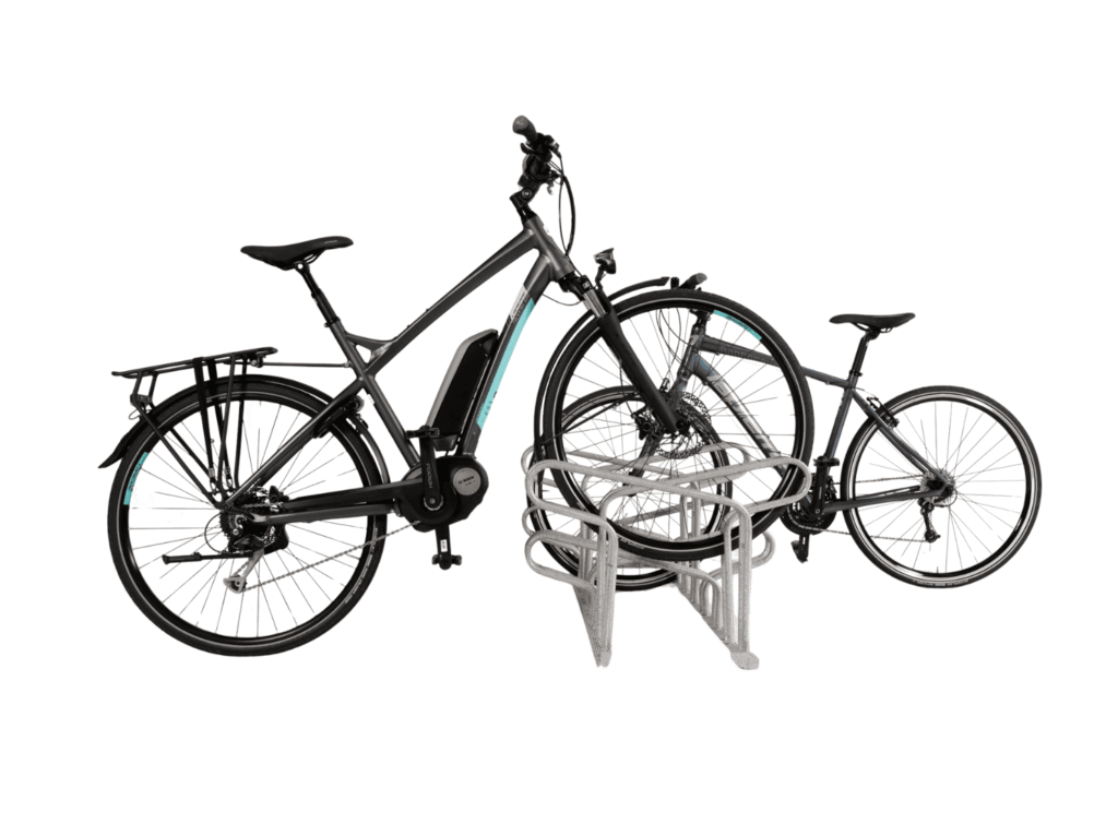 Fahrradständer aus verzinktem Stahl mit zwei abgestellten Fahrrädern, darunter ein Elektrofahrrad, auf einem versetzten Bügel.